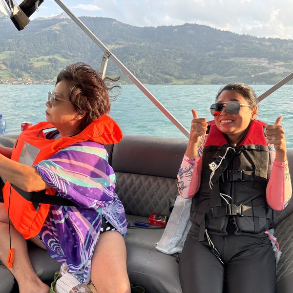 Two women giving thumbs up on Lake Thun